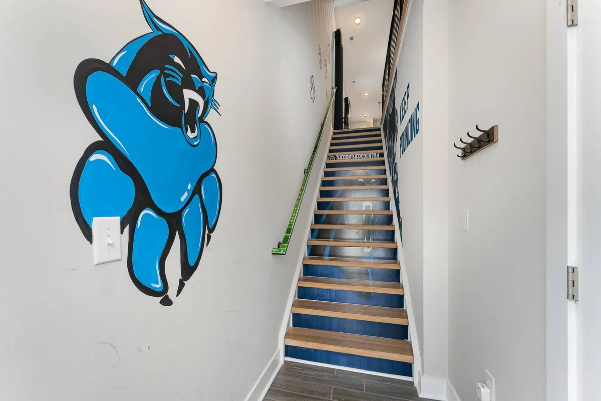 This image captures the entrance area with a striking blue panther mural on the wall and a staircase with blue and wooden steps. The space feels vibrant and inviting, signaling a creative and memorable start to any retreat experience. The visual impact of the mural serves as an engaging conversation starter for arriving guests or team members.