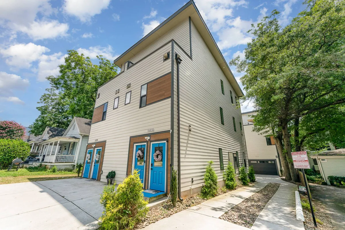 A welcoming exterior shot of the property featuring bright blue doors, modern architectural lines, and well-maintained landscaping. The inviting entry hints at easy access to city adventures.